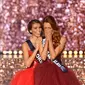 Maeva Coucke (kanan) menutupi wajahnya setelah dinobatkan sebagai Miss France 2018 di Chateauroux, Prancis tengah (16/12). Pada tanggal 23 September 2017 Coucke dinobatkan sebagai Miss Nord-Pas-de-Calais 2017. (AFP Photo/Guillaume Souvant)