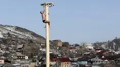 Seorang pria memanjat tiang kayu yang tinggi untuk mendapatkan hadiah selama perayaan Maslenitsa di kota Krasnoyarsk, Rusia, (13/3). perayaan Maslenitsa adalah kegiatan untuk menandai berakhirnya musim dingin di Rusia. (REUTERS / Ilya Naymushin)