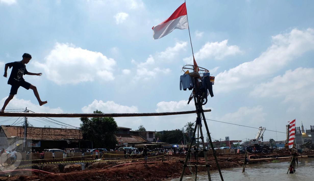 Peserta mengikuti lomba Jalan Pinang di Kalimalang, Jakarta Timur, Senin (17/8). Lomba tersebut dalam rangka menyemarakkan perayaan HUT RI ke-71. (Liputan6.com/Johan Tallo)