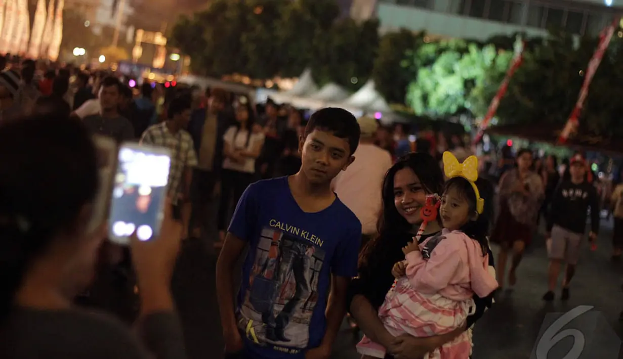 Beberapa warga saat mengabadikan momen mereka saat berada di kawasan Bundaran HI, Jakarta, Rabu (31/12/2014). (Liputan6.com/Faizal Fanani)