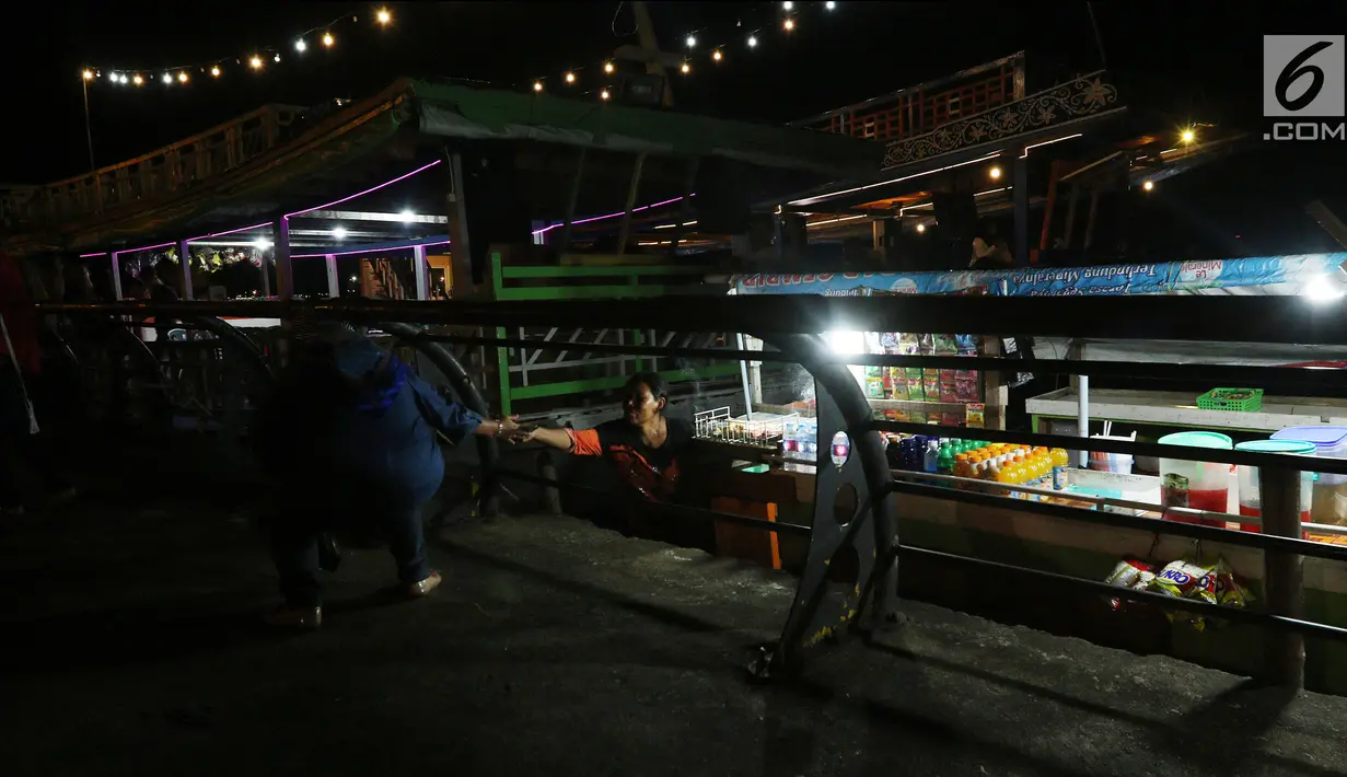 Pedagang melayani pembeli saat menjajakan dagangannya di atas perahu di Alun-Alun Sungai Kapuas, Pontianak, Kalimantan Barat, Kamis (12/4). Akibat dilarang, para pedagang ini memilih berdagang di atas perahu. (Liputan6.com/Johan Tallo)
