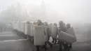 Polisi anti huru hara berjalan untuk menghadang demonstran selama protes di Almaty, Kazakhstan, Rabu (5/2/2022). Demonstran yang mencela kenaikan harga gas cair bentrok dengan polisi di kota terbesar Kazakhstan dan mengadakan protes di sekitar selusin kota lain di negara.(AP Photo/Vladimir Tretyakov