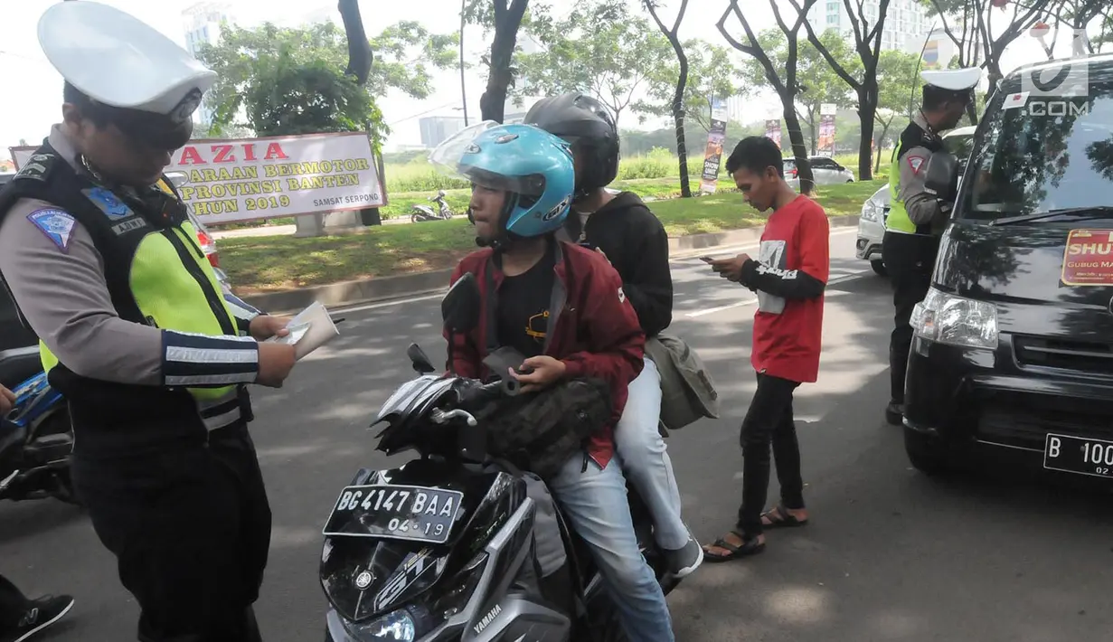 Anggota Satlantas Polres Tangerang Selatan memeriksa kelengkapan surat saat razia pajak kendaraan di Jalan BSD, Tangerang Selatan, Kamis (24/1). Razia juga untuk meningkatkan tertib lalu lintas dan disiplin pengendara bermotor. (Merdeka.com/Arie Basuki)