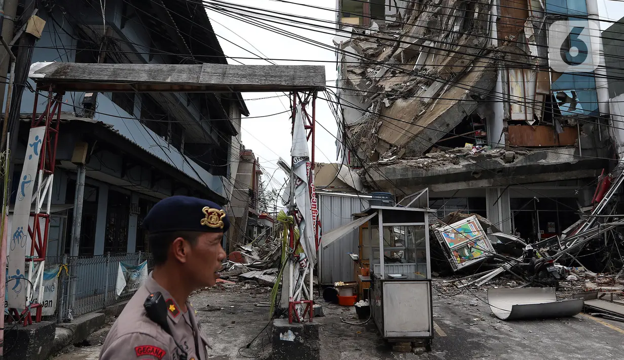 Polisi mengamankan sekitar gedung yang ambruk di Jalan Brigjen Katamso, Kota Bambu Selatan, Palmerah, Jakarta Barat, Senin (6/1/2020). Tiga orang dilaporkan terluka akibat tertima material gedung empat lantai tersebut. (Liputan6.com/Johan Tallo)