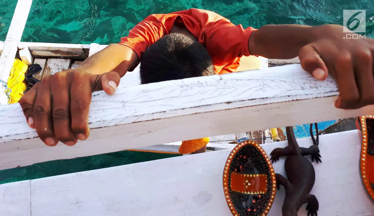Albin berusaha naik ke atas kapal semi pinisi dengan membawa barang dagangan di Pink Beach, Taman Nasional Komodo, Sabtu, (9/10). Menjadi tentara adalah ciita-cita dari kedua kakak beradik ini. (Liputan6.com/Fery Pradolo)