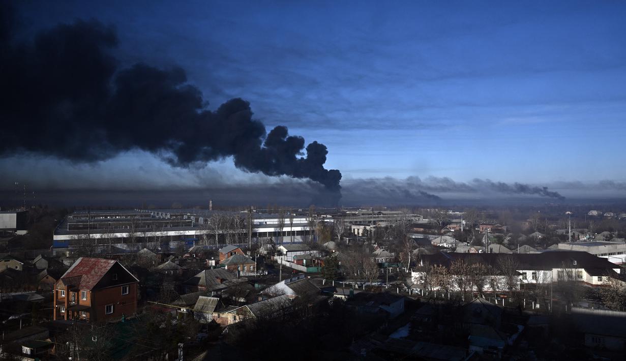 Asap hitam mengepul dari bandara militer di Chuguyev, dekat Kharkiv, 24 Februari 2022. Presiden Rusia Vladimir Putin mengumumkan operasi militer di Ukraina. (Aris Messinis/AFP)