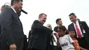 Seorang anak bersalaman dengan PM Denmark Lars Lokke Rasmussen didampingi Menko Kemaritiman, Luhut Pandjaitan di bantaran sungai belakang Museum Bahari, Jakarta, (28/11). Kedatangannya guna mendukung agenda kelautan Indonesia. (Liputan6.com/Angga Yuniar)
