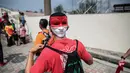Seorang suporter Timnas Indonesia memakai topeng akan menonton pertandingan melawan Timor Leste pada laga SEA Games di Stadion MPS, Selangor, Minggu (20/8/2017). Indonesia menang 1-0 atas Timor Leste. (Liputan6/Faizal Fanani)