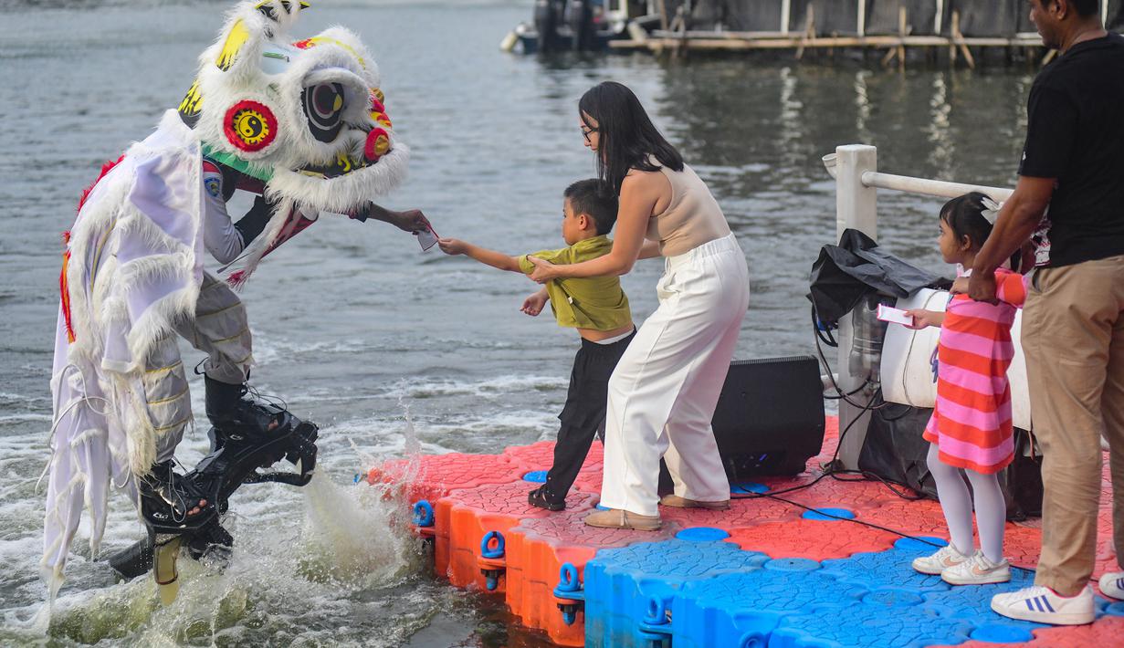 Atraksi barongsai menari di atas air akan berlangsung hingga Selasa 17 Februari 2026 pada pukul 17.00 dan 19.00 WIB. Tampak dalam foto, penampil mengenakan kostum barongsai beratraksi Aerial Lion Dance di Danau Senayan Park, Jakarta, 14 Februari 2026. (merdeka.com/Arie Basuki)