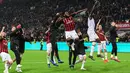 Gelandang AC Milan, Franck Kessie (tengah) dan rekan setimnya merayakan kemenangan bersama suporter usai pertandingan melawan Lazio pada lanjutan Liga Serie A Italia di stadion San Siro (13/4). Milan menang tipis 1-0 atas Lazio berkat gol penalti Kessie. (AFP Photo/Miguel Medina)