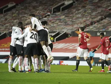 Para pemain AC Milan melakukan selebrasi setelah bek Simon Kjaer mencetak gol di menit 90+2 ke gawang Manchester United pada pertandingan leg pertama babak 16 besar Liga Europa di Old Trafford, Inggris, Jumat (12/3/2021). MU bermain imbang atas AC Milan 1-1. (AP Photo/Dave Thompson)