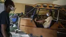 Adolfo Rivera (70) berpose di dalam pesawat yang dia buat di garasi gedung apartemennya di Havana, Kuba, 19 Februari 2021. Rivera yang merupakan insinyur mekanik dan profesor universitas tersebut menciptakan pesawat terbang kayu, dua tempat duduk selama delapan tahun. (AP Photo/Ramon Espinosa)
