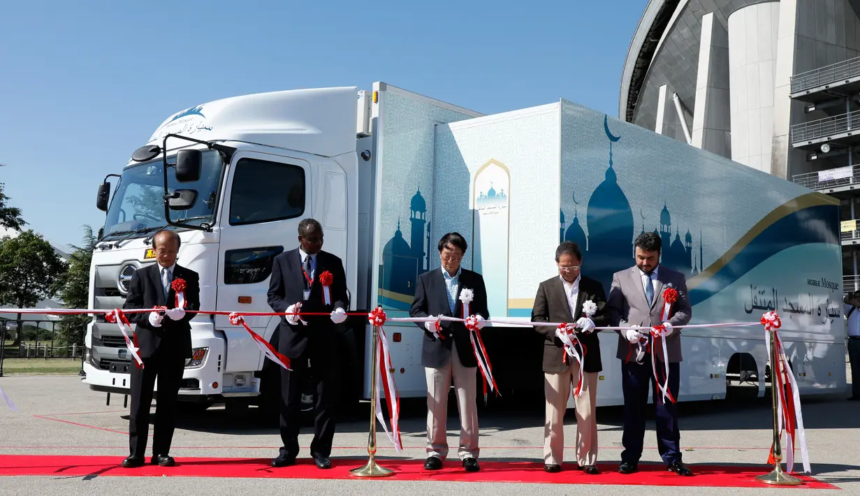 Para tamu memotong pita saat peresmian truk masjid di Toyota Stadium, Jepang, Senin (23/7). Truk masjid untuk Olimpiade 2020 ini berkapasitas hingga 50 orang. (Mobile Mosque Executive Committee via AP)