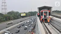 Pekerja menderek rangkaian kereta LRT Jabodebek yang baru tiba di Stasiun Harjamukti, Cibubur, Minggu (13/10/2019). Pengiriman prasarana gerbong LRT produksi PT INKA ke Jakarta dilakukan melalui jalur Tol Trans Jawa dan diangkut menggunakan multi-axle. (merdeka.com/Iqbal S Nugroho)
