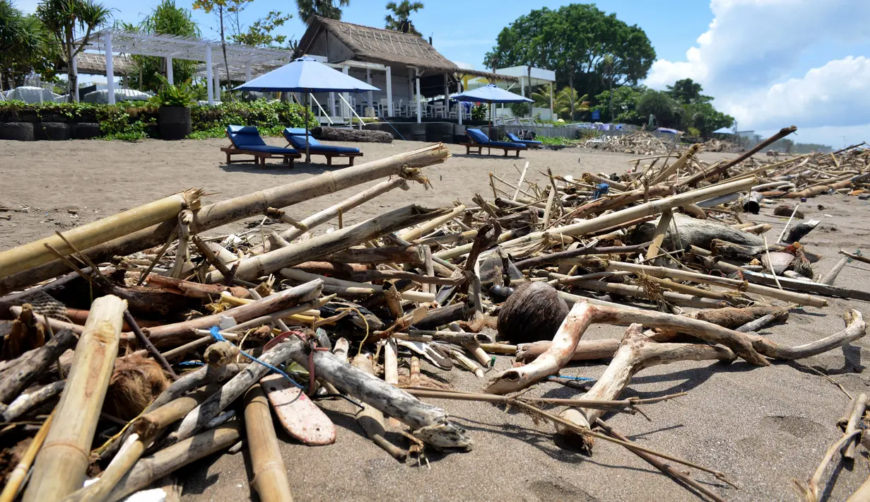 Tumpukan puing dan sampah memenuhi pantai setelah tersapu badai lepas pantai di Batu Belig di Kabupaten Badung, Bali (14/12/2021). Tumpukan sampah plastik dan puing tersebut mencemari bibir pantai. (AFP/Sony Tumbelaka)