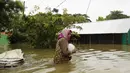 Seorang wanita menerjang banjir di Sunamganj, Bangladesh, Minggu (12/7/2020). Banjir di sejumlah wilayah Bangladesh telah memengaruhi kehidupan lebih dari 1,3 juta orang dan mengakibatkan puluhan ribu keluarga mengungsi. (Xinhua)
