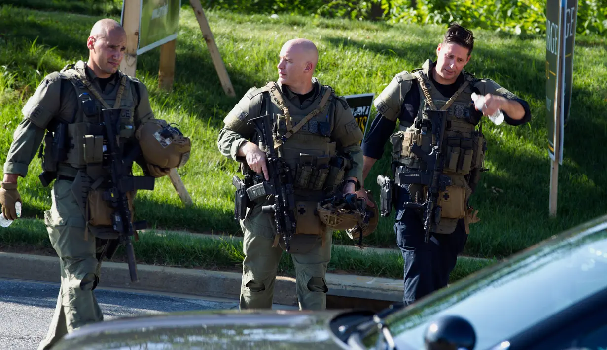 Aparat kepolisian berjalan menuju lokasi penembakan brutal di kantor surat kabar lokal di Annapolis, AS, Kamis (28/6). Pelaku langsung ditangkap tanpa perlawanan setelah melakukan serangan  di kantor Capital Gazette. (AP/Jose Luis Magana)