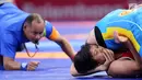 Pegulat Kirgizstan Medet Kyzy Aiperi mengunci pegulat putri Indonesia, Ridwan Ridha Wahyadaniyaty pada kelas putri 76 Kg di JCC Senayan, Selasa (21/8). Pada perdelapan final, Ridha kalah atas lawanya dengan skor 0-12. (Liputan6.com/Fery Pradolo)