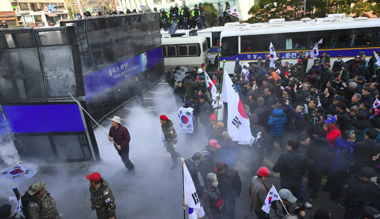 Demo pemakzulan Presiden Korea Selatan (Korsel), Park Geun-hye, berujung ricuh di Seoul, Jumat (10/3). Dua orang tewas dalam bentrokan antara demonstran dan polisi usai putusan pemakzulan Park Geun-hye dibacakan Mahkamah Konstitusi. (JUNG Yeon-Je/AFP)