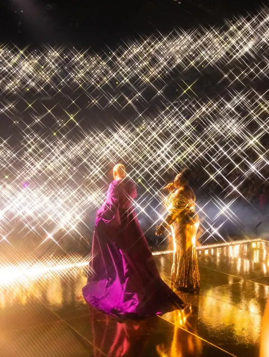 Potret yang diambil dari belakang, tapi kita bisa tahu penampilan Sam Smith yang tak kalah totalitas. Ia mengenakan gaun panjang nan megah berwarna ungu. [Foto: Instagram/samsmith]