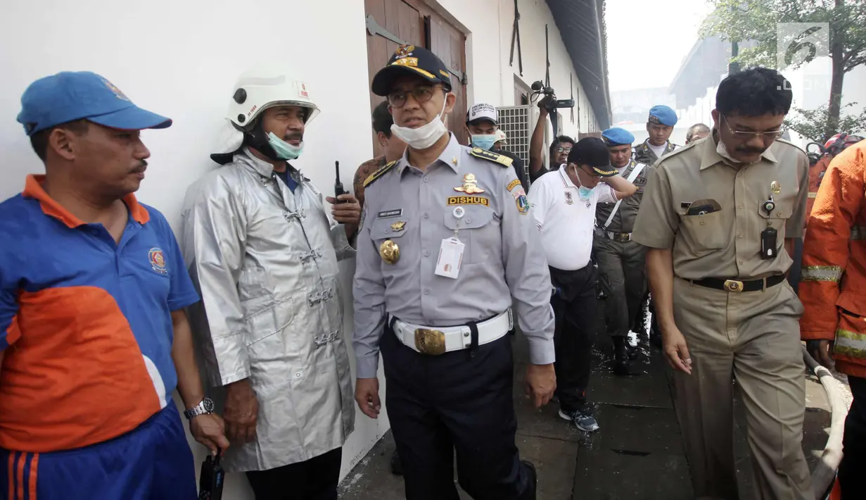 Gubernur DKI Jakarta Anies Baswedan saat meninjau lokasi kebakaran Museum Bahari, di Jalan Pasar Ikan, Penjaringan, Jakarta Utara, Selasa (16/1). Anies datang menggenakan pakaian Dishub ditemani pejabat Pemprov DKI Jakarta. (Liputan6.com/Arya Manggala)