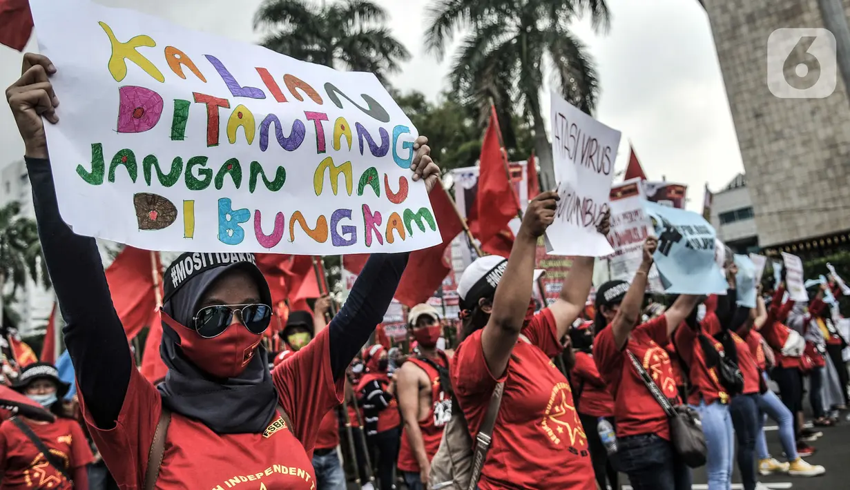 Massa buruh perempuan membentangkan poster tuntutan saat turut dalam aksi menolak UU Cipta Kerja di kawasan Patung Kuda, Jakarta, Selasa (10/11/2020). Dalam aksinya massa buruh mendesak Presiden Jokowi untuk membatalkan UU Cipta Kerja. (merdeka.com/Iqbal S. Nugroho)