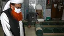 Umat Muslim menggulung karpet sajadah dari aula utama masjid menyusul pembatasan baru pemerintah baru menjelang bulan suci Ramadan di Rawalpindi, Pakistan, Senin (5/4/2021). Warga di atas 50 tahun dan mereka yang menderita sakit harus menghindari datang ke masjid. (Aamir QURESHI/AFP)