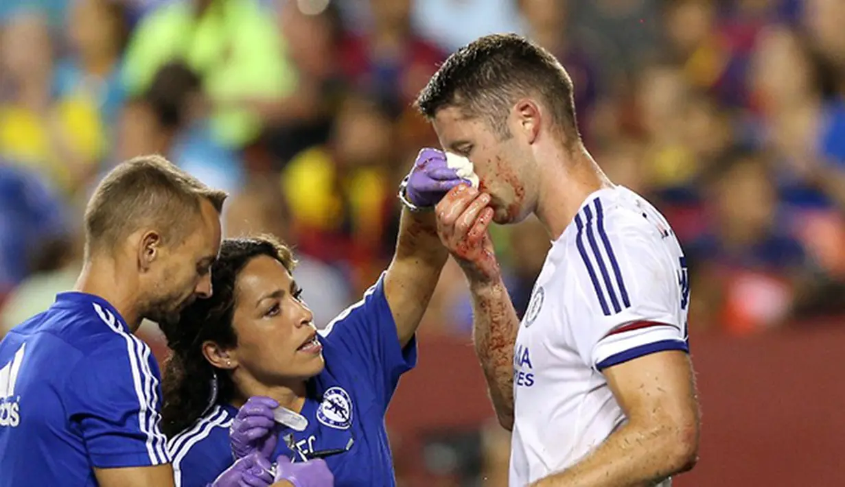 Pemain Chelsea Gary Cahill mendapatkan pengobatan dari tim medis akibat terluka karena duel udara saat mencetak gol pada Laga International Champions Cup di FedEx Field, AS, Rabu (29/7/2015) pagi WIB. (AFP/Getty Images/ Patrick Smith)
