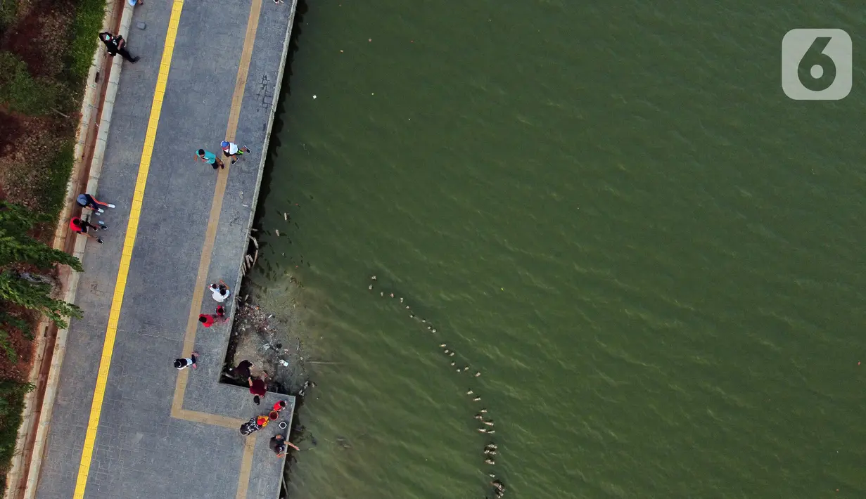 Foto udara memperlihatkan aktivitas warga di pedestrian Danau Sunter, Jakarta, Sabtu (27/6/2020). Beragam aktivitas dilakukan warga sambil menikmati waktu sore di area Danau Sunter, Jakarta. (Liputan6.com/Helmi Fithriansyah)