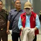 Tersangka korupsi Ujang Iskandar, dengan tangan terborgol dan wajah tertutup topi serta masker, tiba di Palangka Raya diiringi oleh petugas kejaksaan, Rabu (21/8/2024).