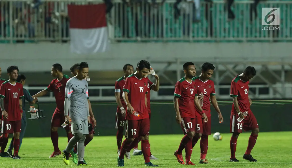 Pemain timnas Indonesia U-23 tertunduk usai kalah melawan Korea Selatan U-23 pada laga persahabatan di Stadion Pakansari, Kab Bogor, Sabtu (23/6). Indonesia U-23 kalah 1-2. (Liputan6.com/Helmi Fithriansyah)