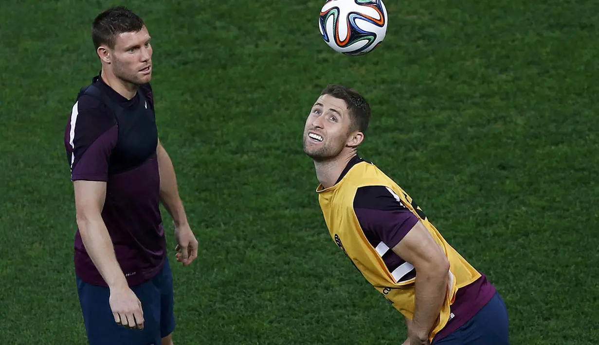 Pemain belakang Inggris, Gary Cahill (kanan) dan James Milner berlatih permainan bola atas di Stadion Corinthians, Sao Paolo, Brasil, (19/6/2014). (REUTERS/Ivan Alvarado)