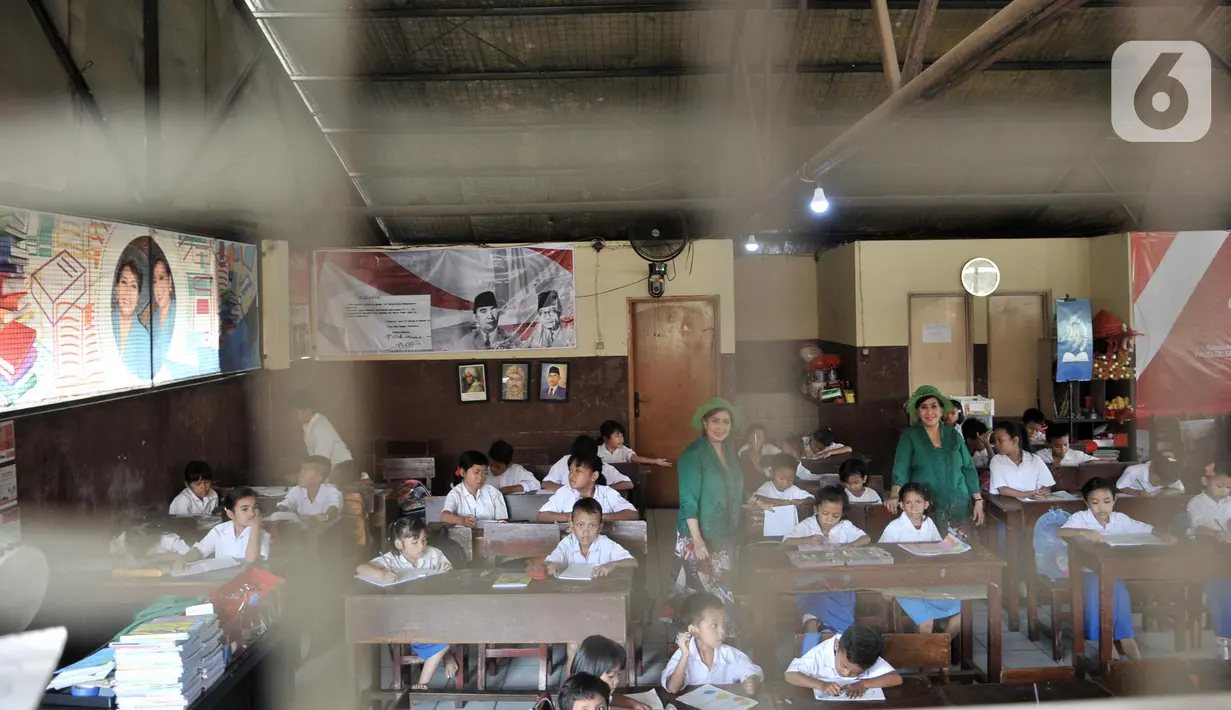 Sri Irianingsih (kanan) dan Sri Rossyati (kiri) saat mengajar siswa Sekolah Darurat Kartini di kawasan Lodan, Jakarta Utara, Senin (25/11/2019). Kini, tercatat ada 300 peserta didik mengikuti kegiatan di sekolah sejak pukul 07.00 hingga 12.00 WIB setiap Senin-Jumat. (merdeka.com/Iqbal Nugroho)