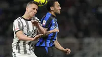 Pemain Juventus, Arkadiusz Milik (kiri) berduel dengan pemain Inter Milan,&nbsp;Hakan Calhanoglu (kanan), pada leg kedua semifinal Coppa Italia di Stadion Giuseppe Meazza, Kamis (27/4//2023) dini hari WIB. (AP Photo/Luca Bruno)