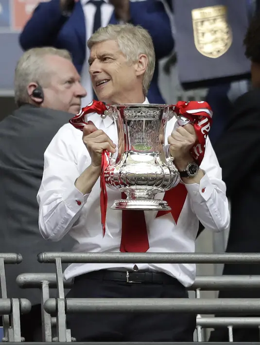 Pelatih Arsenal, Arsene Wenger memegang trofi Piala FA di Stadion Wembley, London, Sabtu (27/5). Arsenal mengalahkan Chelsea 2-1 dalam laga final Piala FA 2016-2017. (AP Photo)