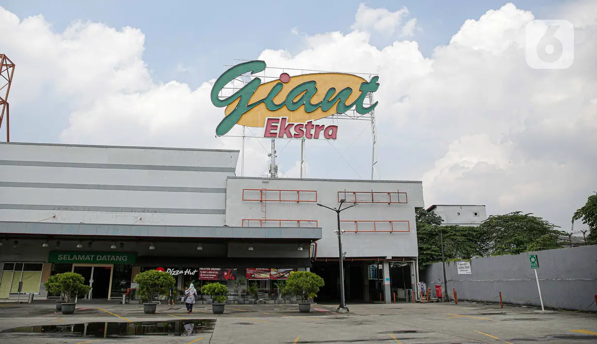 Pengunjung melintas di depan Supermarket Giant Ekstra di Kreo, Tangerang, Senin (2/8/2021). PT Hero Supermarket Tbk resmi menutup seluruh gerai Giant di Indonesia pada Minggu (1/8/2021), dan akan lebih fokus pada pengembangan gerai merek lainnya. (Liputam6.com/Faizal Fanani)