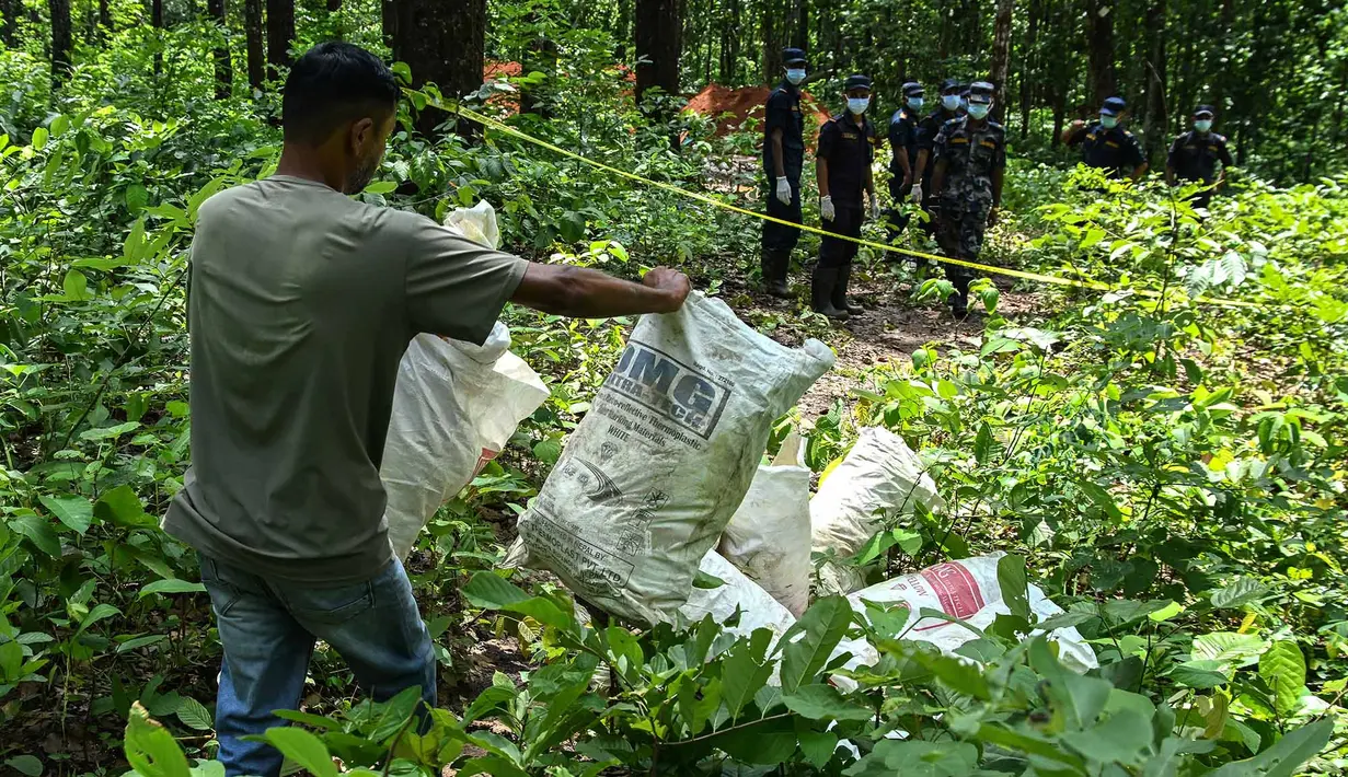 Pekerja membawa bagian tubuh korban saat pemakaman massal para korban banjir bandang mematikan di Devghat, Distrik Chitwan, Nepal,  Minggu, 30 Agustus 2026. (AFP/ Prakash Mathema)