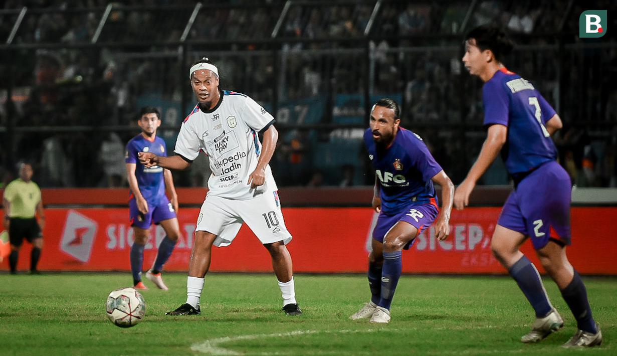 Ronaldinho kembali turun ke lapangan hijau. Mantan bintang Barcelona itu turut ambil bagian dalam acara trofeo Meet the Star di Stadion Kanjuruhan, Kabupaten Malang, Minggu (26/6/2022). (Bola.com/Iwan Setiawan)