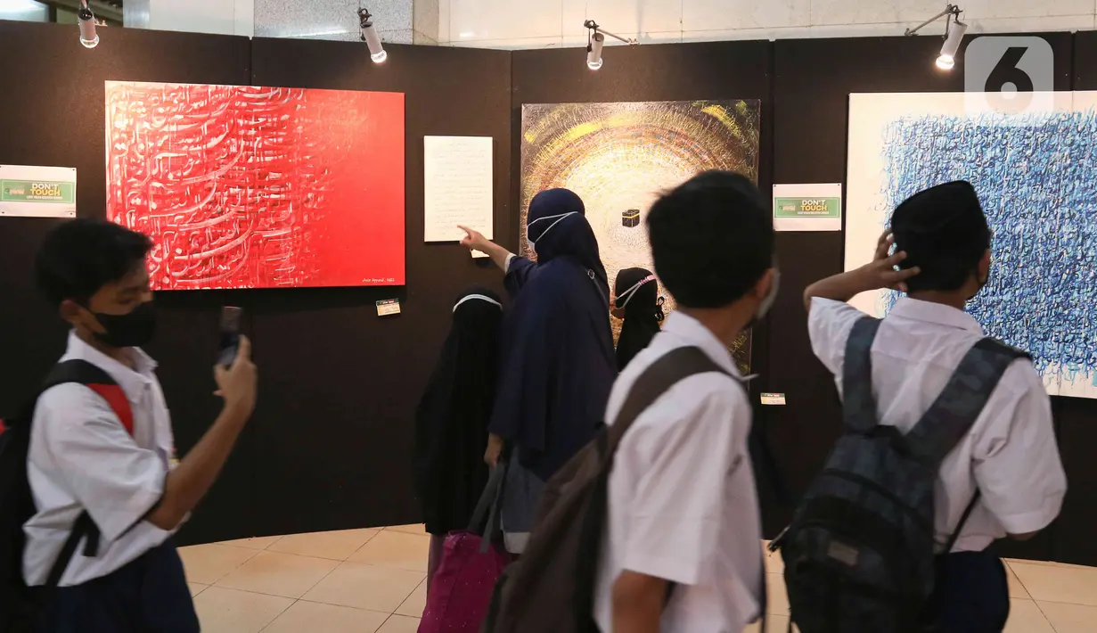 Pengunjung melihat karya yang dipamerkan pada Pameran Kaligrafi Kontemporer Internasional di Masjid Raya Jakarta Islamic Center, Jakarta, Senin (18/4/2022). Pameran Kaligrafi Kontemporer Internasional berlangsung hingga 22 April 2022. (Liputan6.com/Herman Zakharia)