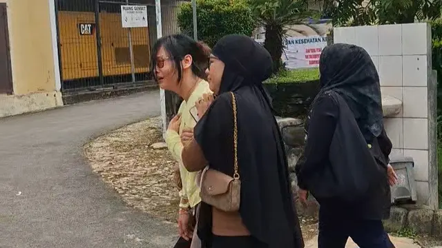 Istri Brigpol Arya Supena menangis di RS Bhayangkara Lampung. (Liputan6.com/Ardi Munthe)
