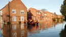 Petugas menggunakan perahu karet menyisir lokasi pemukiman warga yang terendam banjir parah di York, Inggris utara, Minggu (27/12). Banjir akibat luapan sungai Ouse yang telah memperburuk sejumlah wilayah Inggris utara. (REUTERS/Phil Noble)