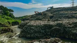 Kondisi aliran Kali Pesanggrahan yang menyempit di kawasan Pasir Putih, Depok, Jawa Barat, Senin (27/4/2026), setelah longsoran sampah dari Tempat Pembuangan Akhir (TPA) Cipayung menutup sebagian badan sungai. (merdeka.com/Arie Basuki)