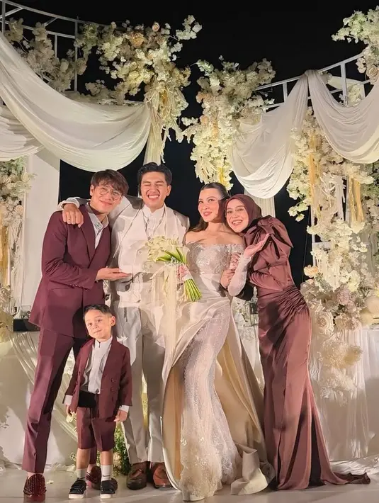 Lesti Kejora dan Rizky Billar sama-sama menjadi bridesmaid dan groomsmen di pernikahan Harris dan Haviza dengan pakaian warna maroon. Lesti tampil dengan long dress lengan panjang puff. Dan Rizky Billar dibalut setelan jas. [@lestikejora]