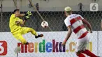 Kiper PSS Sleman Eka Rizky menghalau tendangan bek Madura United Jaimerson pada laga Piala Menpora 2021 di Stadion Si Jalak Harupat, Bandung, Jawa Barat, Selasa (23/3/2021). Madura United menang 2-1 atas PSS Sleman. (Bola.com/M Iqbal Ichsan)