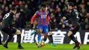 Pemain Crystal Palace Wilfried Zaha, berusaha melewati pemain Asrsenal saat pertandingan Liga Inggris di stadion Selhurst Park di London (28/12). Crystal Palace harus menelan kekalahan dikandang sendiri 2-3 atas Arsenal. (AP Photo/Alastair Grant)