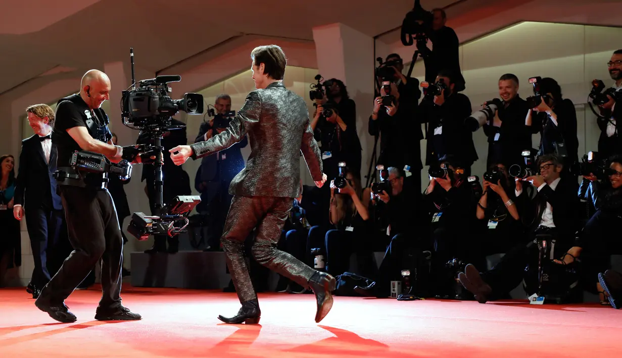 Aktor Jim Carrey bergaya di depan kamera saat menghadiri pemutaran film 'Jim and Andy: The Great Beyond' selama Festival Film Venice ke-74 di Venesia, Italia, (5/9). Komedian 55 tahun ini terihat usil di acara tersebut. (AFP Photo/Domenico Stinellis)