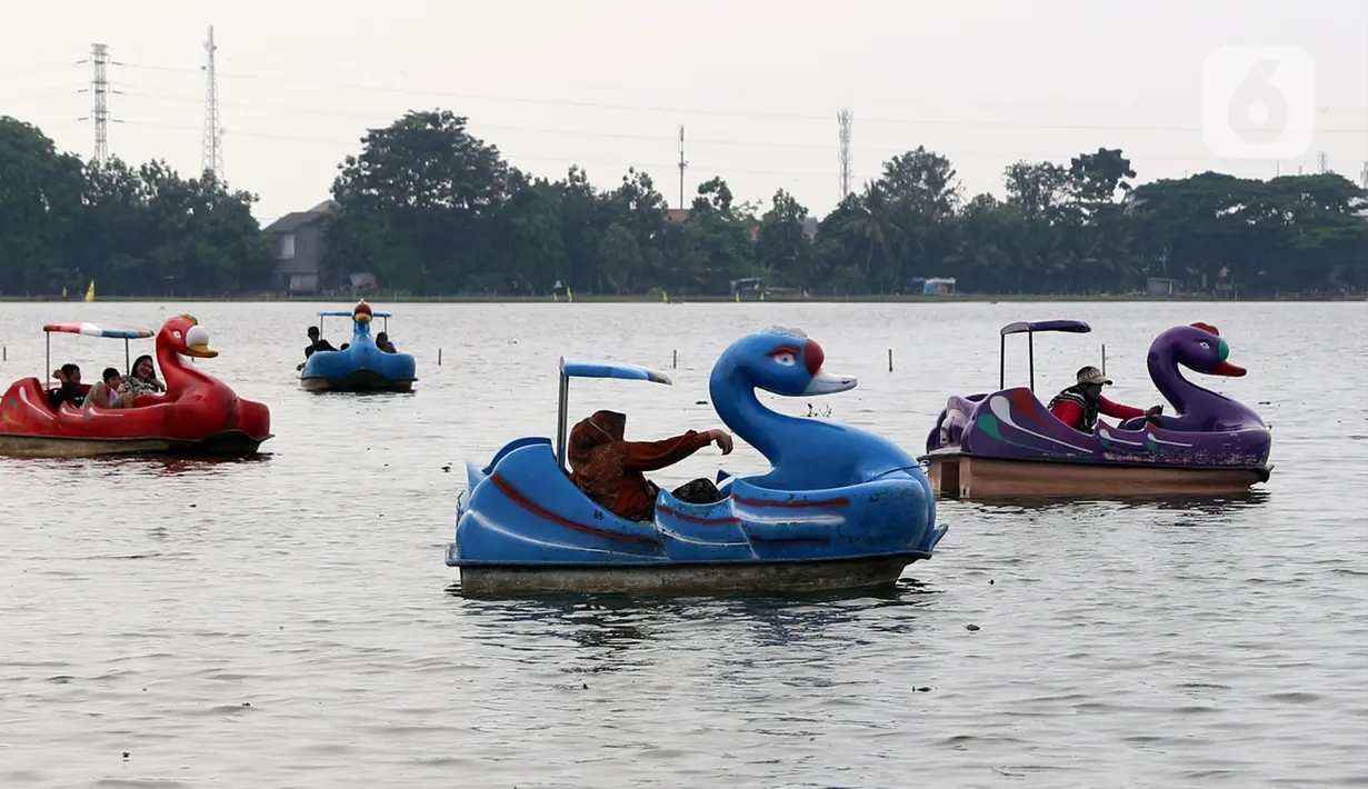 Warga menikmati wahana air di Danau Cipondoh, Kota Tangerang, Banten, Rabu (20/10/2021). Banyak warga memanfaatkan hari libur Maulid Nabi untuk berwisata bersama keluarga di kawasan tersebut sebagai alternatif wisata di tengah kota. (Liputan6.com/Angga Yuniar)