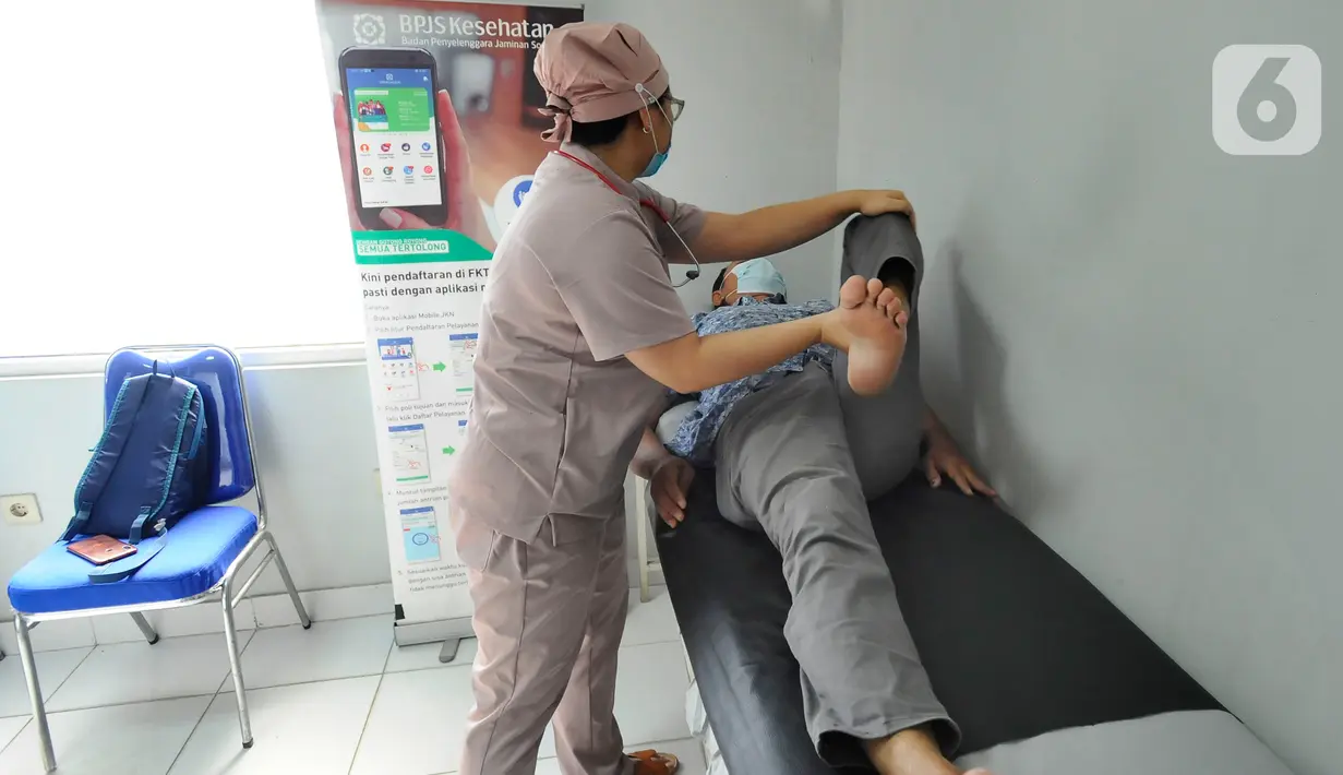 Dokter Natasha memeriksa pasien BPJS Kesehatan yang berobat di Faskes Tingkat 1 Klinik Kesehatan Prima Husada di Depok, Jawa Barat, Senin (23/5/20222). Sejumlah terobosan saat ini dilakukan paramedis di Faskes Tingkat 1, diantaranya antre berobat bisa dilakukan secara online melalui aplikasi mobile JKN. (merdeka.com/Arie Basuki)
