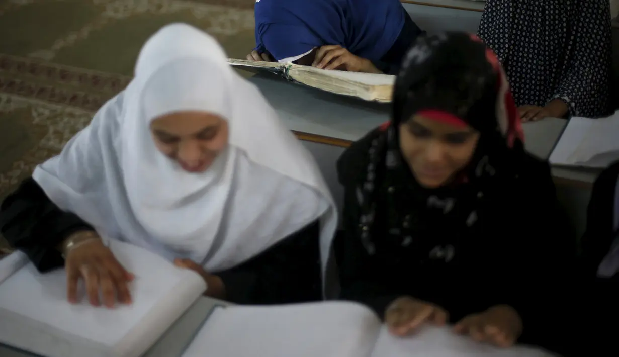 Gadis penyandang tunanetra membaca Alquran versi Braille di Gaza, Palestina, Kamis (18/6). Bulan Ramadan, ribuan warga Palestina, termasuk penyandang tunanetra mendapat pelajaran membaca dan menghafal Alquran secara gratis. (REUTERS/Suhaib Salem)