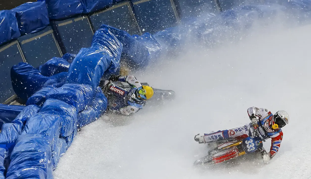 Igor Kononov (kiri) dari Rusia terjatuh ketika ingin menyalip rekan setimnya Dmitry Khomitsevich di FIM Ice Speedway Gladiator di Kazakhstan (21/2). Tak jarang pembalap terjatuh karena licinnya sirkuit es tersebut. (REUTERS/Shamil Zhumatov)